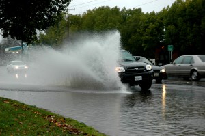 A Toyota pickup drives through the flood on Freeport and makes a splash. 